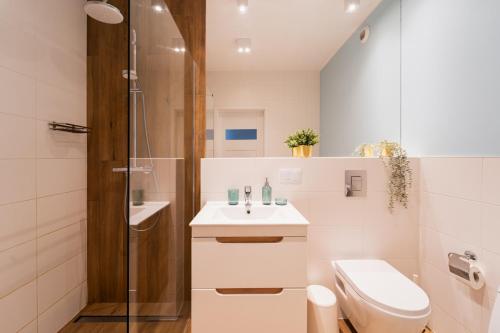ein Bad mit einem WC, einem Waschbecken und einer Dusche in der Unterkunft Nice Apartment - Near Sky Tower - Private Parking in Breslau