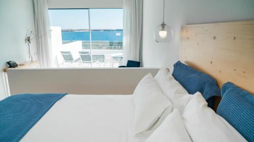 a bedroom with a bed with a view of the ocean at CalaLanzarote Suites Hotel - Adults Only in Playa Blanca