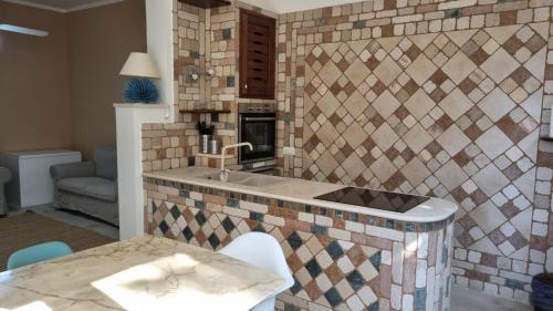 a kitchen with a sink and a tile wall at Villa Ada Casa Vacanze in Torre Specchia Ruggeri
