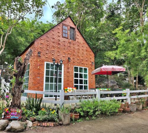 a brick building with a window and an umbrella at Hua Hin Home Hill in Hua Hin