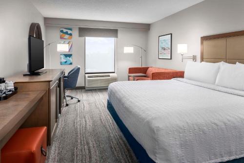 a hotel room with a bed and a flat screen tv at Hampton Inn & Suites at Lake Mary Colonial Townpark in Lake Mary