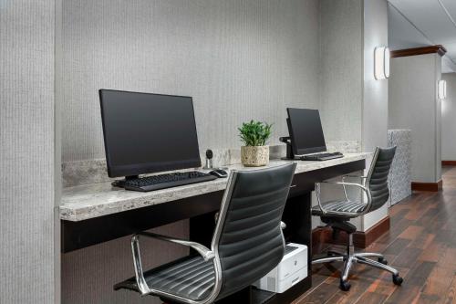 an office with two computers on a desk with chairs at Hampton Inn & Suites at Lake Mary Colonial Townpark in Lake Mary