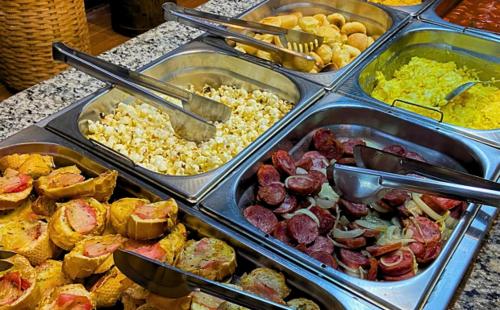 a buffet filled with different types of food in trays at Pousada Jovimar in Aparecida