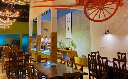 a dining room with a table and chairs and a wheel on the wall at Pousada Jovimar in Aparecida