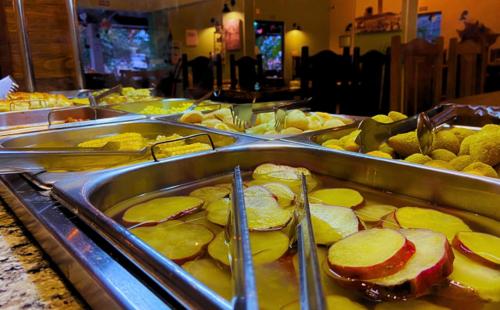 a buffet line with many trays of food at Pousada Jovimar in Aparecida