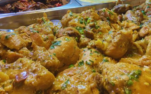 a tray of food with chicken and other food items at Pousada Jovimar in Aparecida