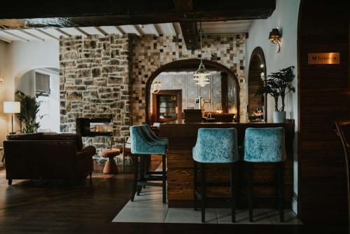 una sala de estar con un bar con sillas azules en The Croft Hotel, BW Signature Collection, en Darlington