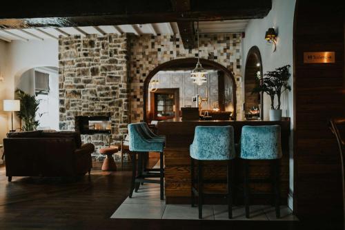 a living room with a bar with blue chairs at The Croft Hotel in Darlington