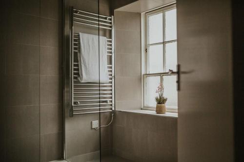 a bathroom with a shower with a mirror and a window at The Croft Hotel, BW Signature Collection in Darlington