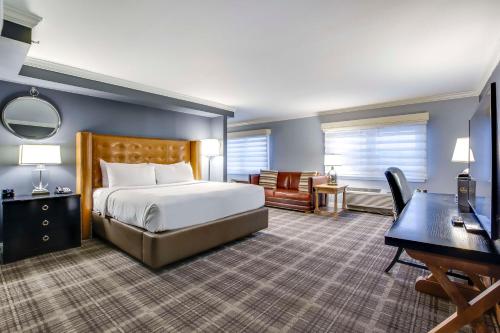 a hotel room with a bed and a desk and a computer at The Campbell House Lexington, Curio Collection by Hilton in Lexington