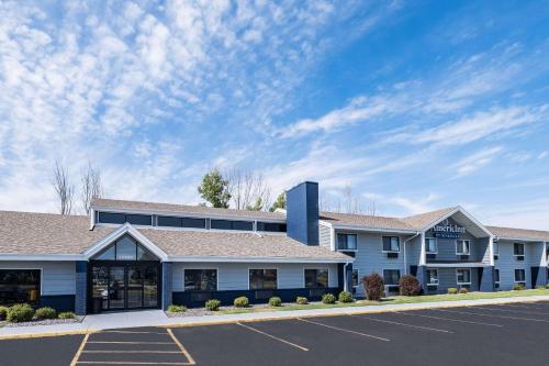 a large blue building with a parking lot at AmericInn by Wyndham Plover Stevens Point in Plover