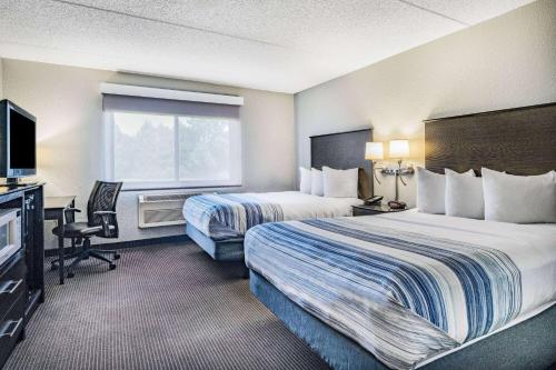 a hotel room with two beds and a television at AmericInn by Wyndham Plover Stevens Point in Plover