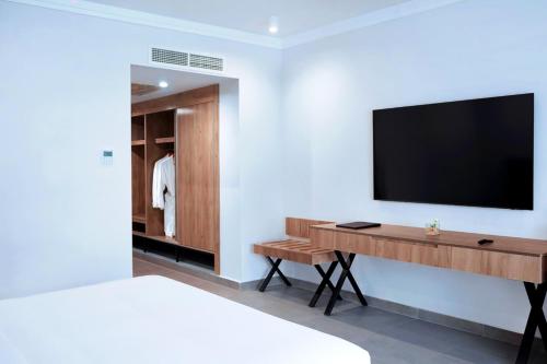 a bedroom with a desk and a television on a wall at Pickalbatros Blu Spa Resort - Adults Friendly 16 Years Plus- Ultra All-Inclusive in Hurghada