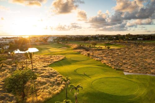 an aerial view of a golf course with palm trees at Radisson Blu Azuri Resort & Spa in Roches Noires