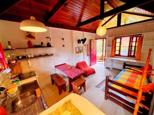 a kitchen and living room with a table and chairs at Condomínio Aldeia in Abraão