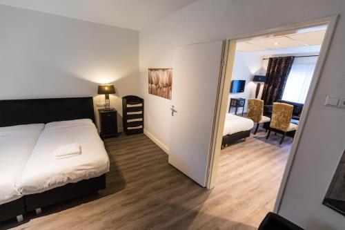 a hotel room with a bed and a mirror at Hotel de Duif Lisse - Keukenhof in Lisse