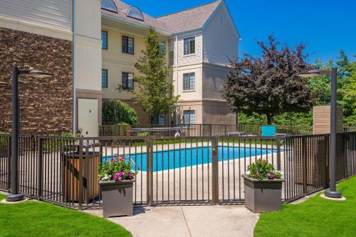 a house with a fence and a swimming pool at Sonesta ES Suites Andover Boston in Andover