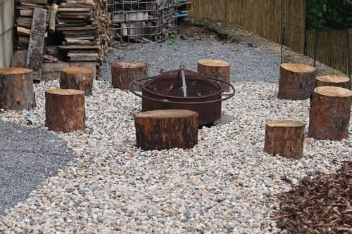 a fire pit surrounded by logs and a bunch of stumps at Bohemian Paradise near Prague with Wellness in Řehenice