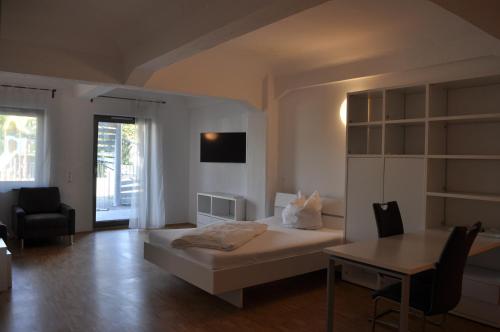 a bedroom with a bed and a table and a chair at New Age Boardinghouse in Heilbronn