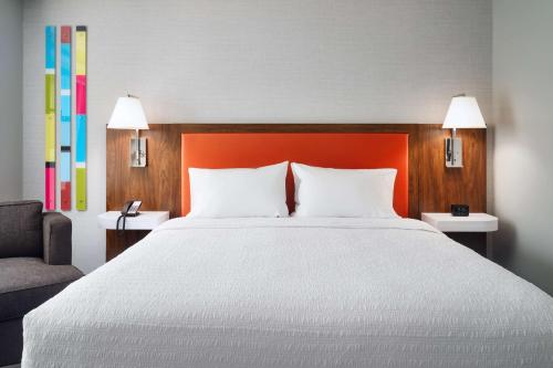 a bedroom with a large white bed and a chair at Hampton Inn Towson Downtown in Towson