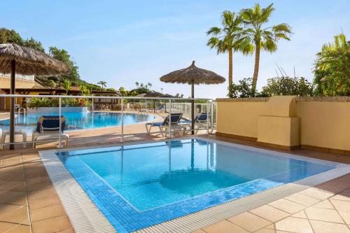 a pool at a resort with palm trees at Wyndham Residences Costa Adeje in Adeje