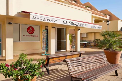 a building with a bench in front of a store at Wyndham Residences Costa Adeje in Adeje