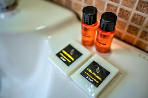 two bottles of essential oils sitting on a bathroom sink at Casa Eternal Boutique Hotel - Calangute in Calangute