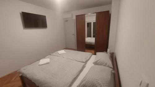 two beds in a small room with a mirror at Apartman i Sobe Vasilić in Jurandvor