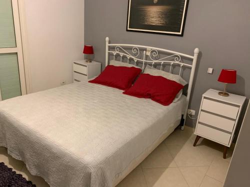 een slaapkamer met een bed met 2 rode kussens bij Guarujá/Acapulco Cond alto padrão in Guarujá