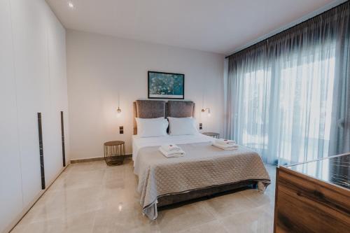 a bedroom with a bed and a large window at Pearl Apartel in Volos