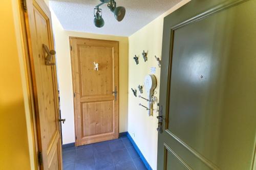 a hallway with a wooden door and a room at Le Col Roulé in Valloire