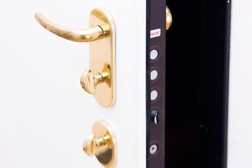 a door with brass handles on a white wall at Prione's Apartment in Genova