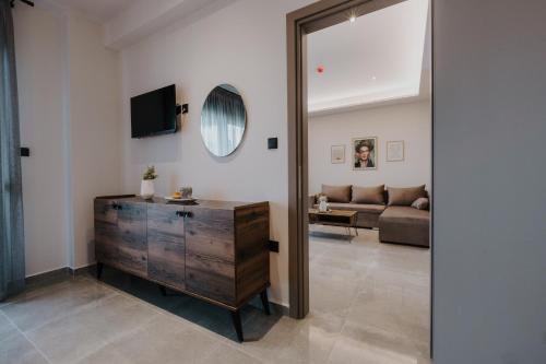 a living room with a mirror and a wooden dresser at Pearl Apartel in Volos