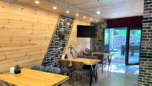 ein Restaurant mit Holzwänden und Tischen und Stühlen in der Unterkunft Mezrasuit Bungalov in Çamlıhemşin