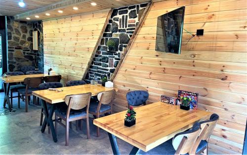 ein Restaurant mit Holzwänden sowie Holztischen und -stühlen in der Unterkunft Mezrasuit Bungalov in Çamlıhemşin