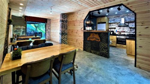 ein Esszimmer mit einem Holztisch und einer Küche in der Unterkunft Mezrasuit Bungalov in Çamlıhemşin