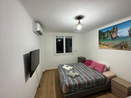 une chambre avec un lit et une télévision à écran plat dans l'établissement Appartement climatisé avec balcon, à Fréjus