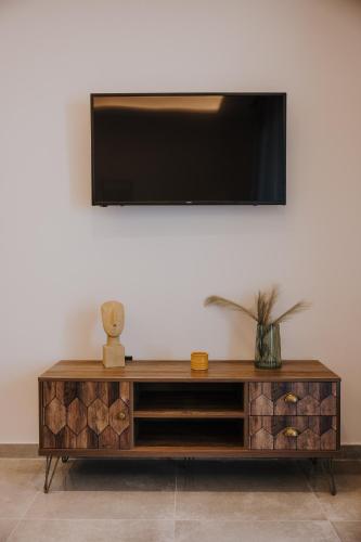 a wooden entertainment center with a television on a wall at Pearl Apartel in Volos