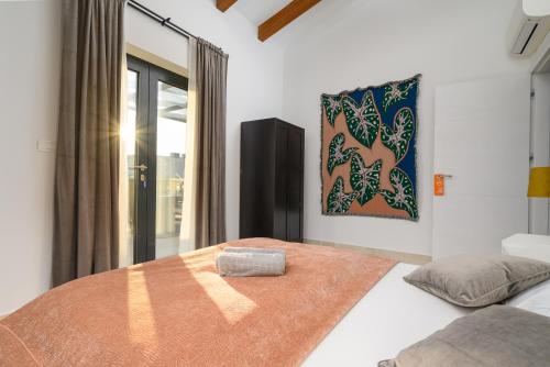 a bedroom with a bed and a painting on the wall at Villa Linnelle seaview- Rovinj, heated pool in Burići