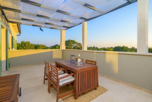 a patio with a table and chairs on a balcony at Villa Linnelle seaview- Rovinj, heated pool in Burići