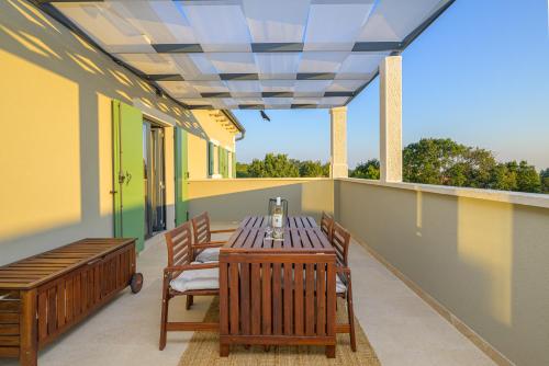 a patio with a table and chairs on a balcony at Villa Linnelle seaview- Rovinj, heated pool in Burići