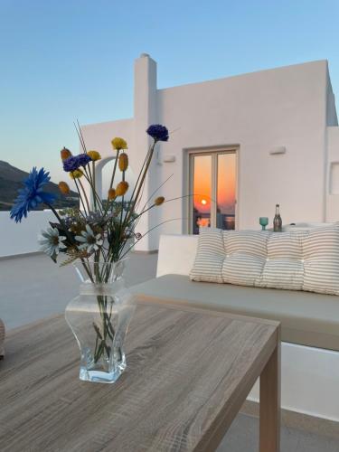 a vase of flowers sitting on a table in a living room at thErοs - Sunset view apartment in Parikia