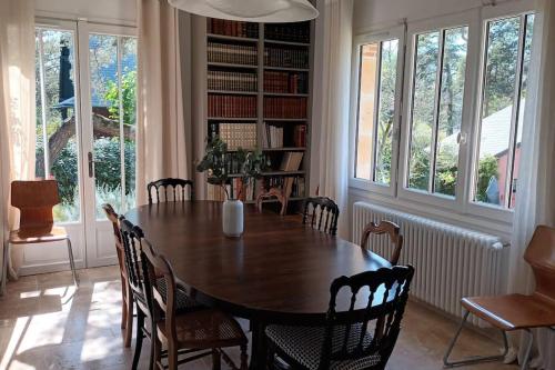 une salle à manger avec une table et des chaises en bois dans l'établissement Villa d'exception à 500 m de la plage, à Merville-Franceville-Plage