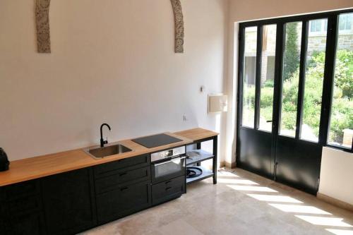 - une cuisine avec un évier et un comptoir avec une fenêtre dans l'établissement Villa d'exception à 500 m de la plage, à Merville-Franceville-Plage