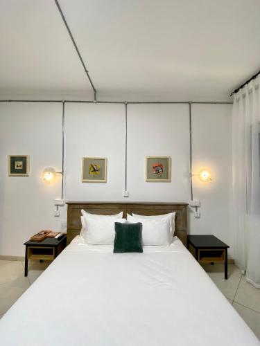 a bedroom with a large white bed with two tables at Le Bijou Chic in the Heart of Saigon Charm with VIEW in Ho Chi Minh City