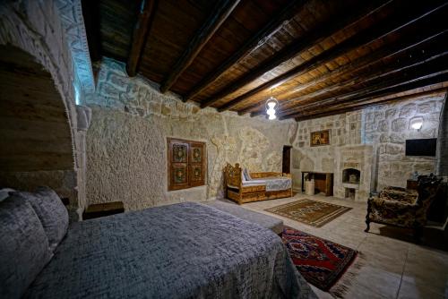 een slaapkamer met een bed en een open haard bij Holiday Cave Hotel in Goreme