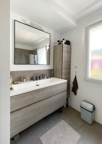 y baño con lavabo y espejo. en Villa contemporaine - Prima Volta, en Niza