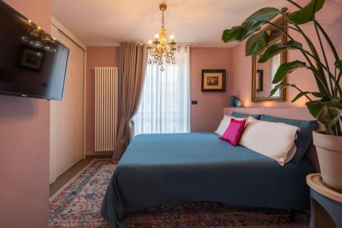 a bedroom with a blue bed and a tv at La Lupa La Morra in La Morra