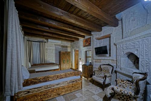 a bedroom with a king sized bed and a fireplace at Holiday Cave Hotel in Göreme