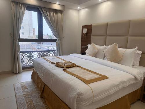 a bedroom with a large bed with a large window at فندق جولدن ايليت Golden Elite Hotel in Al Khobar